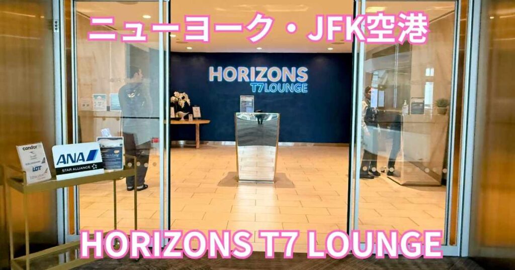 ニューヨーク・JFK空港にある、ANA指定ラウンジ『HORIZONS T7 LOUNGE』のガラス張りの入り口。手前にANAの看板があり、ガラス越しにラウンジ内の様子が見える。