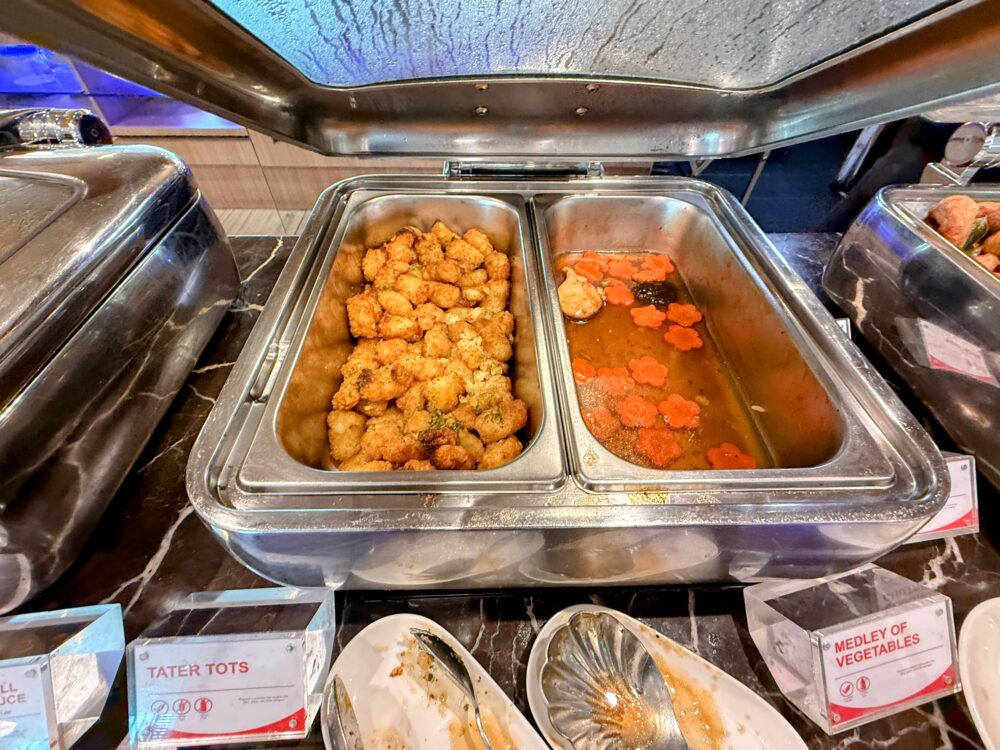 SATSプレミアラウンジのタッツォッツ（Tater Tots）と色鮮やかな温野菜炒めのビュッフェ料理。