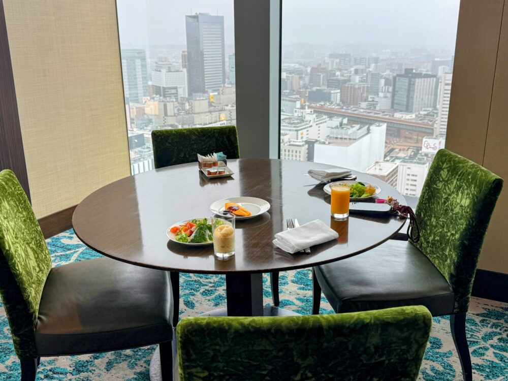 レストランの個室での朝食。窓際の丸テーブルと仙台市街の眺め