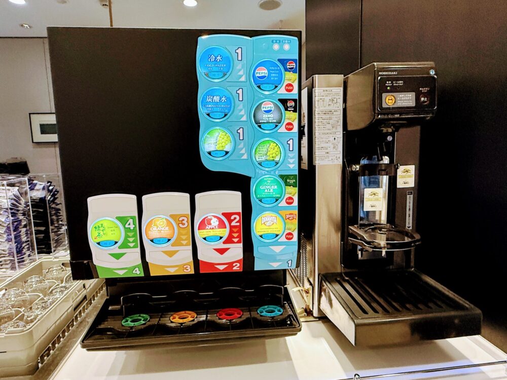 仙台空港ANAラウンジのドリンクサーバーとコーヒーマシン。冷水・炭酸水・ペプシ・ジンジャーエール・緑茶・オレンジ