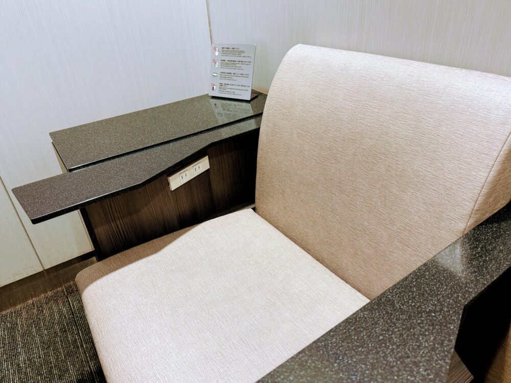 仙台空港ANAラウンジのソファー席。御影石調のテーブルと電源コンセント