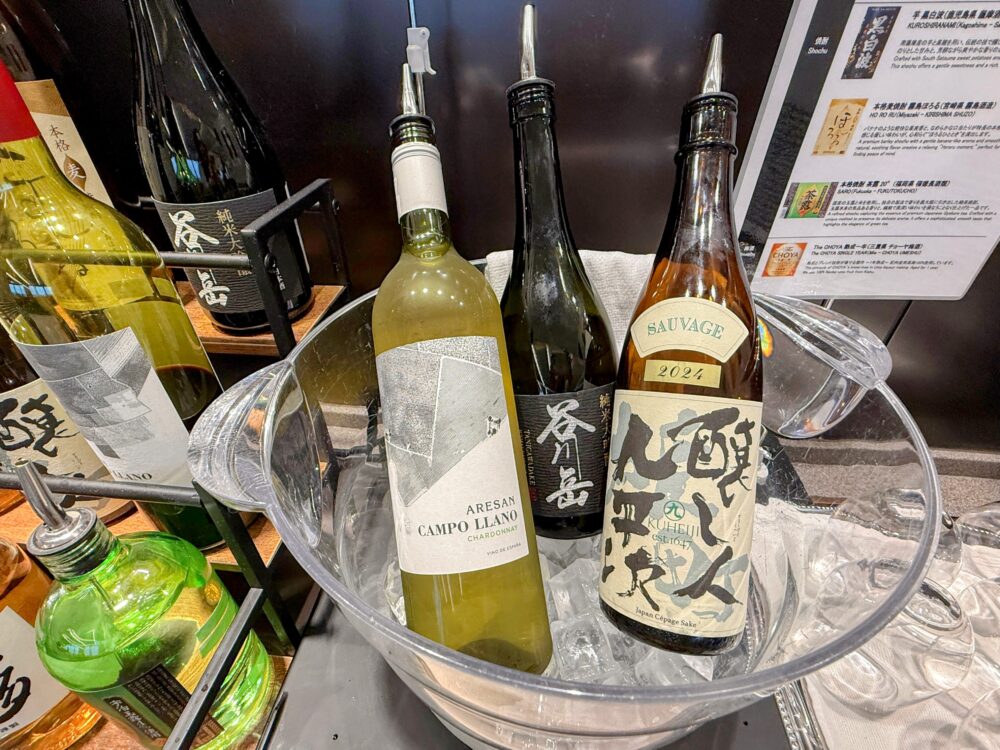 ANAスイートラウンジのワイン・日本酒コーナー。アイスバケットで冷やした白ワインや純米大吟醸などのボトルが並ぶ。