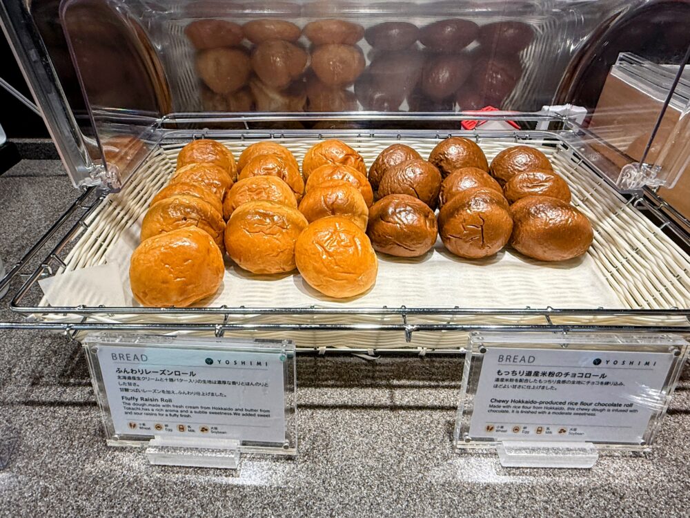 ふんわり焼き上げたレーズンロールがかごに盛られた、ANAスイートラウンジのパンコーナー。