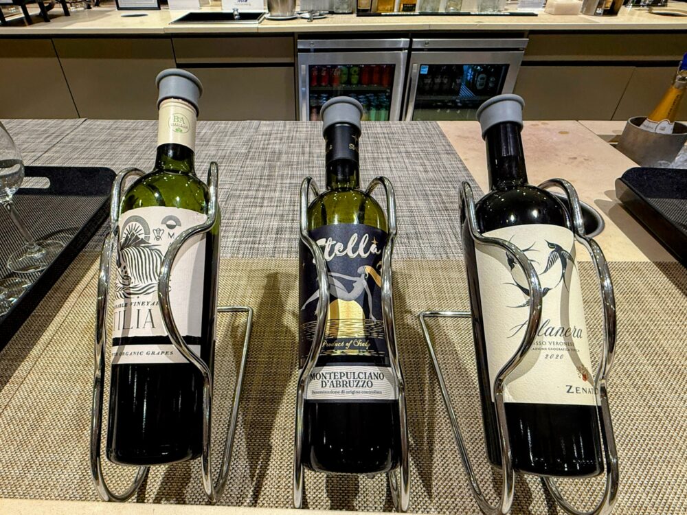 ファーストクラスラウンジのワインスタンド。イタリア産Montepulciano d'Abruzzo(Stella)を中心に赤・白ワイン3本がシルバーのボトルスタンドに立てかけられています。