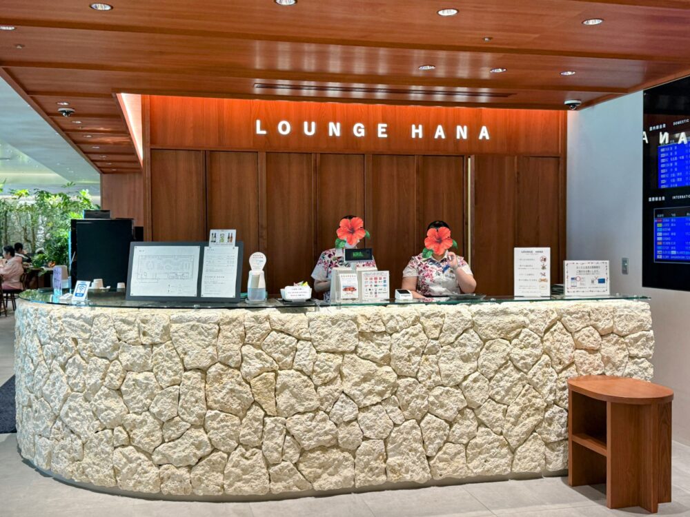 那覇空港カードラウンジ「LOUNGE HANA」の琉球石灰岩のカウンターとスタッフ2名