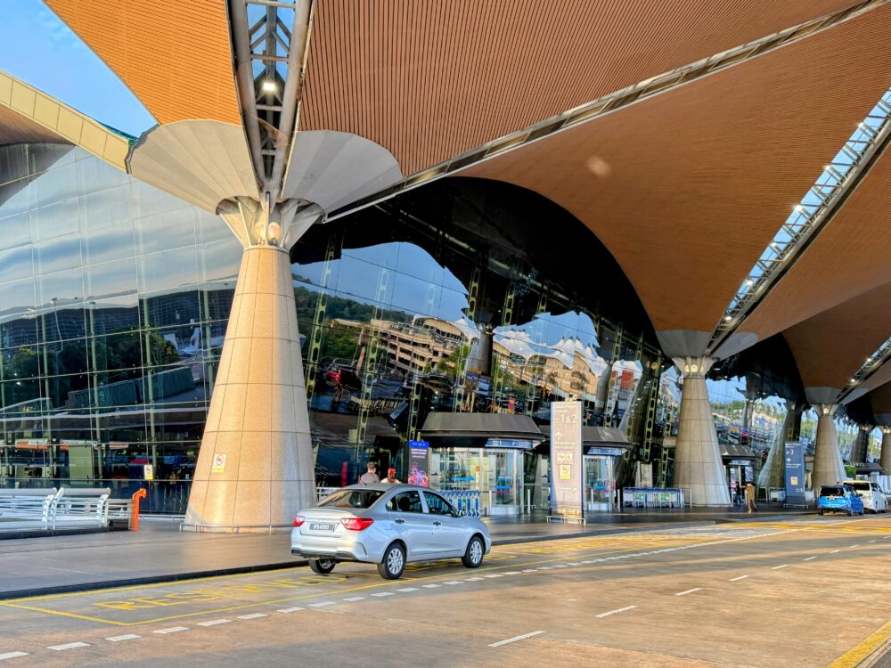 クアラルンプール国際空港第1ターミナルの特徴的な屋根とガラス張りの壮麗な出発ロビー外観