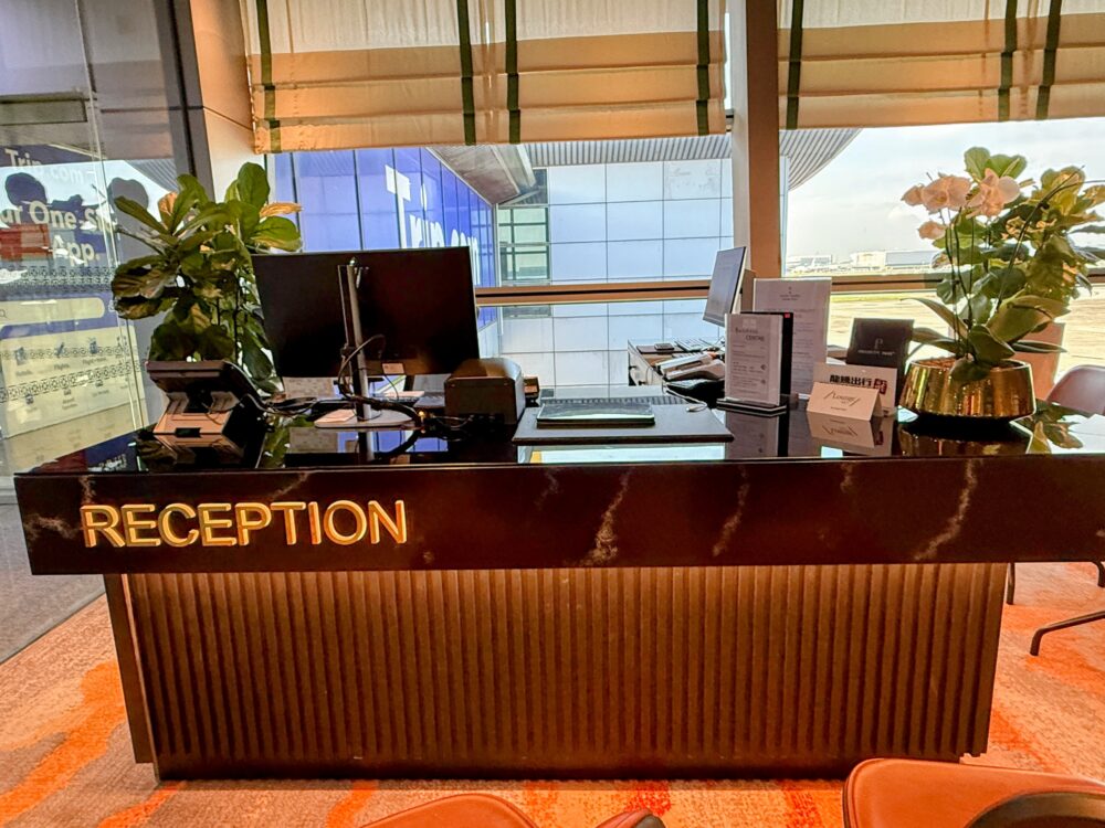 大理石調の高級感ある「Sky Suite Airport Lounge」のレセプションカウンターと窓からの景色