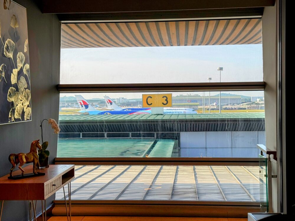 スカイスイートラウンジの窓から見える、マレーシア航空機が駐機するKLIA第1ターミナルの滑走路の眺め