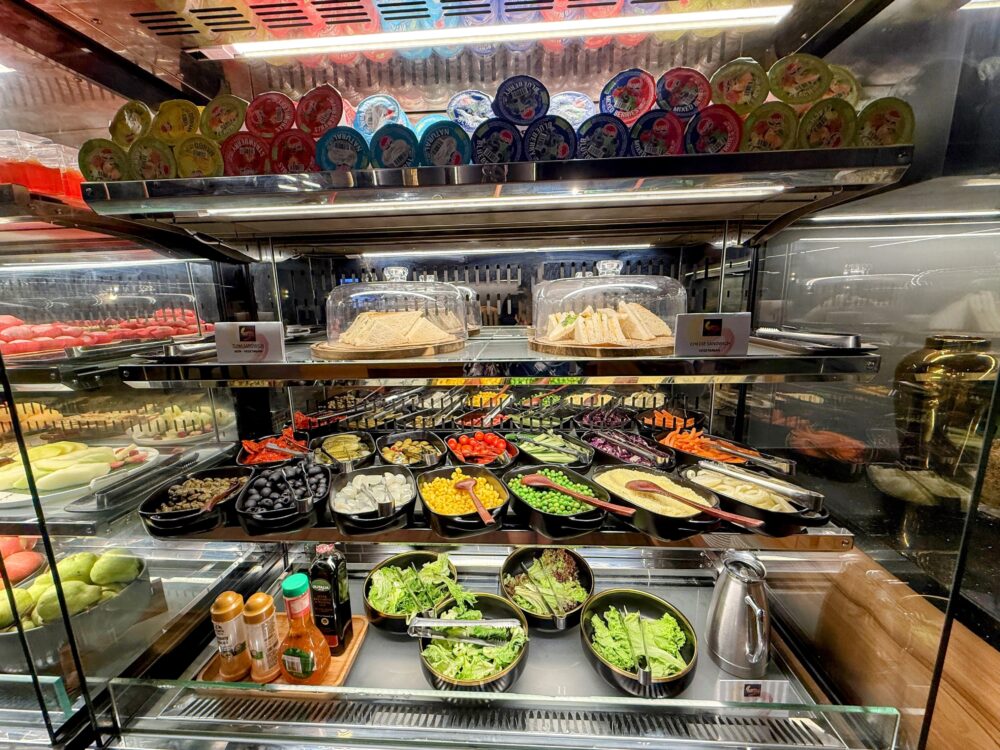 サンドイッチやカット野菜、ドレッシング、カップ入りのヨーグルトなどが並ぶ冷蔵ショーケース