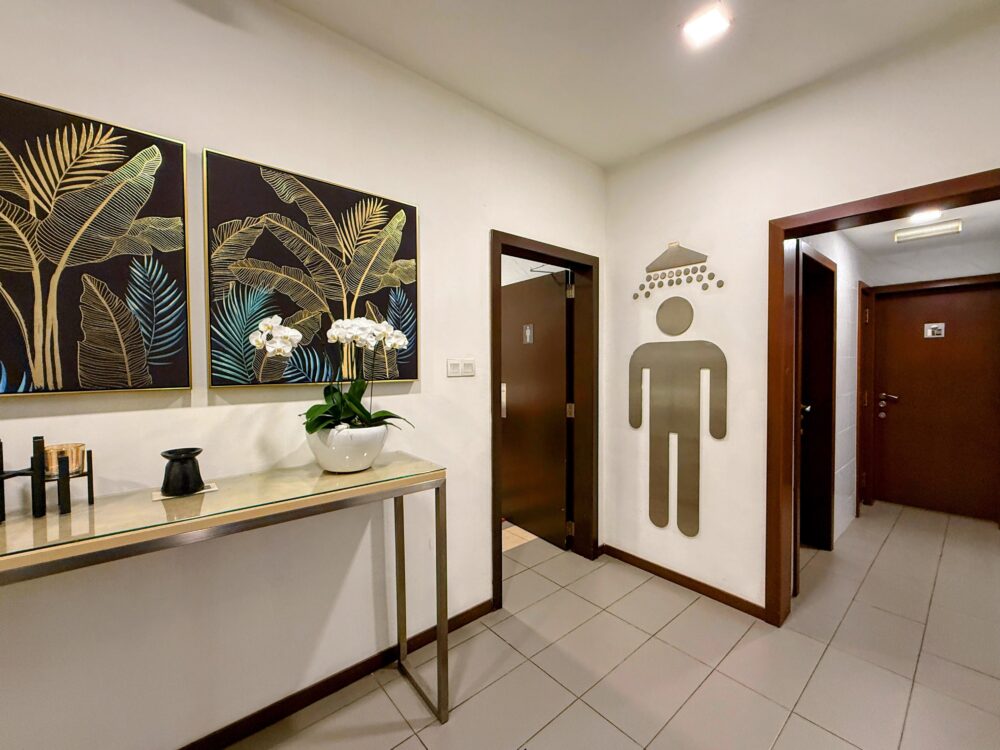金色のボタニカルアートが飾られた、シャワールームやトイレへと続くラウンジ内の廊下