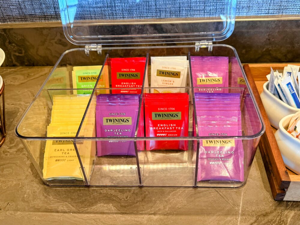 「GLOBAL LOUNGE」に用意されたTWININGS（トワイニング）のティーバッグ。透明なケースに、レモン＆ジンジャー、アールグレイ、ダージリンなどの様々なフレーバーが種類別にきれいに整理されている。