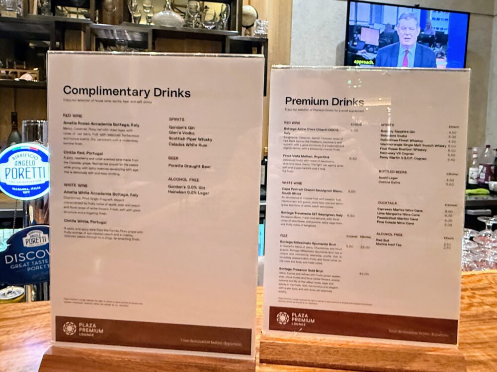 プラザプレミアムラウンジのバーカウンターに置かれた「Complimentary Drinks(無料メニュー)」と「Premium Drinks(有料メニュー)」のドリンクメニュー表。