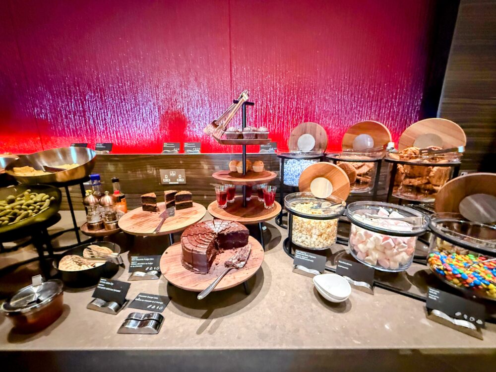 エアカナダ メープルリーフラウンジの、チョコレートケーキやマフィン、スナック類が豊富に並ぶデザート・スナックビュッフェカウンター。