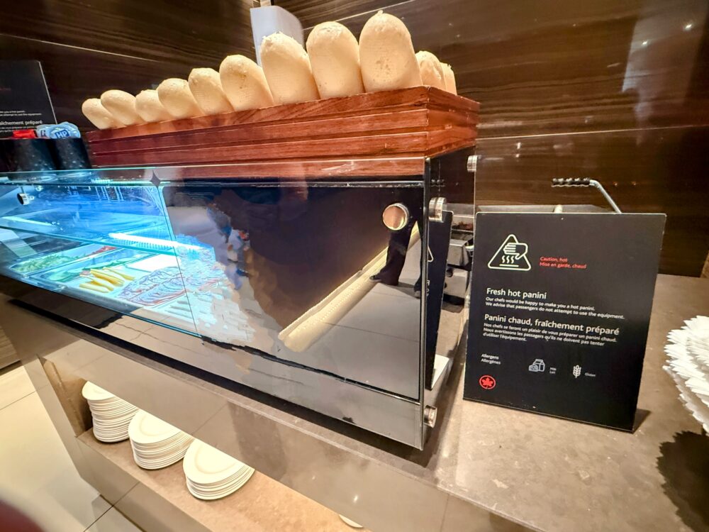 エアカナダ メープルリーフラウンジの、焼き立てのパニーニが作れる調理スペースとフランスパンなどのブレッドが並ぶカウンター。