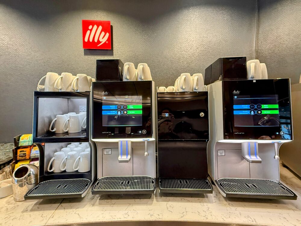 ユナイテッドクラブの、エスプレッソやカプチーノが淹れられる複数の高性能コーヒーマシンとマグカップが並ぶコーナー。