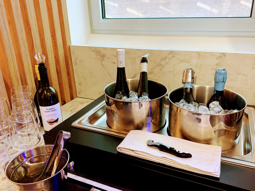 氷の入った金属製クーラーに冷やされた、白ワイン(Tenuta Sant'Anna)やスパークリングワインのボトル。