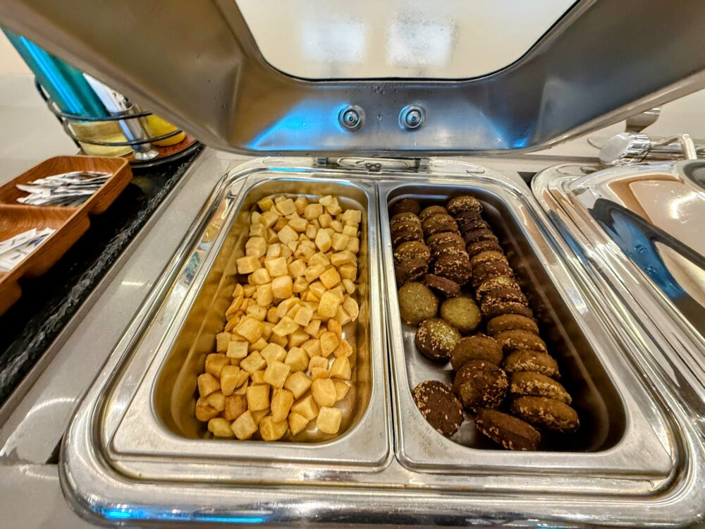 ホットミールとして提供されている一口サイズのポテトと、コロッケやファラフェルのような揚げ物料理。