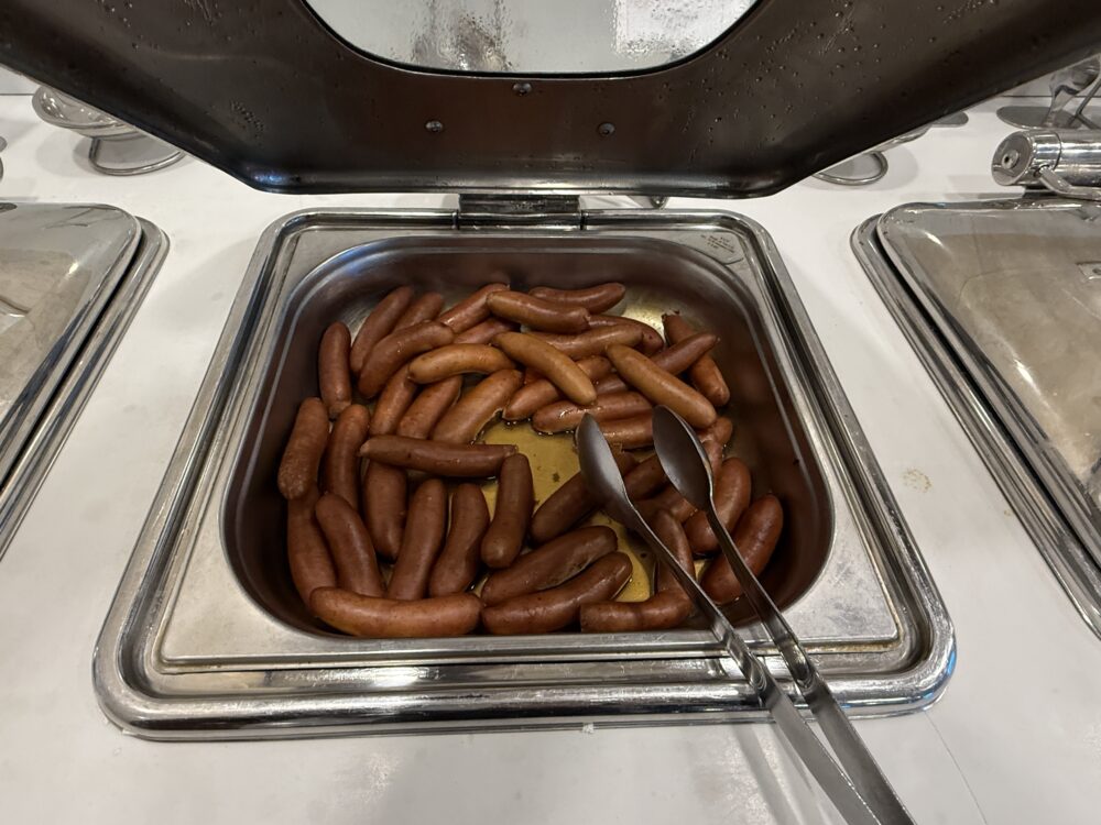 ホットミールの温められたトレイにたっぷりと盛られた、香ばしい焼き色のソーセージ。