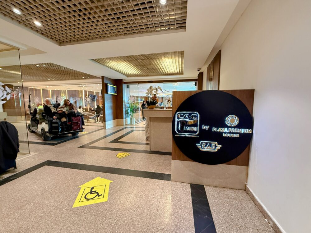 洗練された「CAC Lounge by Plaza Premium Lounge」のエントランスと黒い円形の看板。