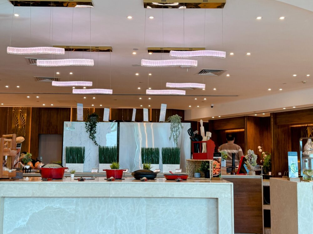 木目調の壁に掲げられた「CAC by PLAZA PREMIUM LOUNGE」の黒い円形看板。
