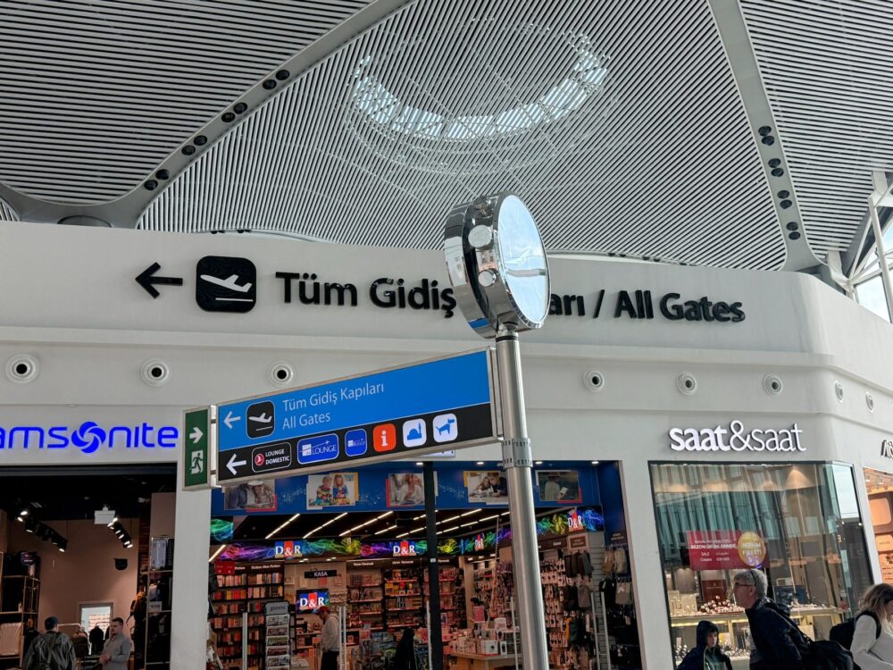 イスタンブール空港出発フロアの案内板。All Gatesの表示の下にLOUNGE DOMESTIC(国内線ラウンジ)の矢印