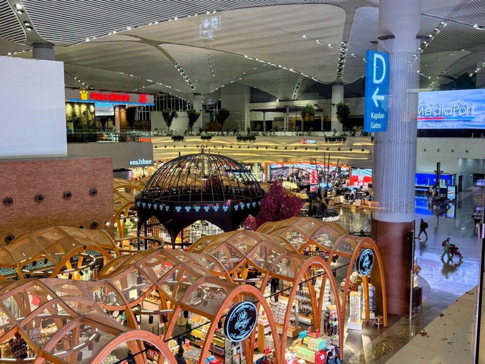 イスタンブール空港内の高い天井とアーチ状の木製装飾が特徴的なショッピングエリアの風景
