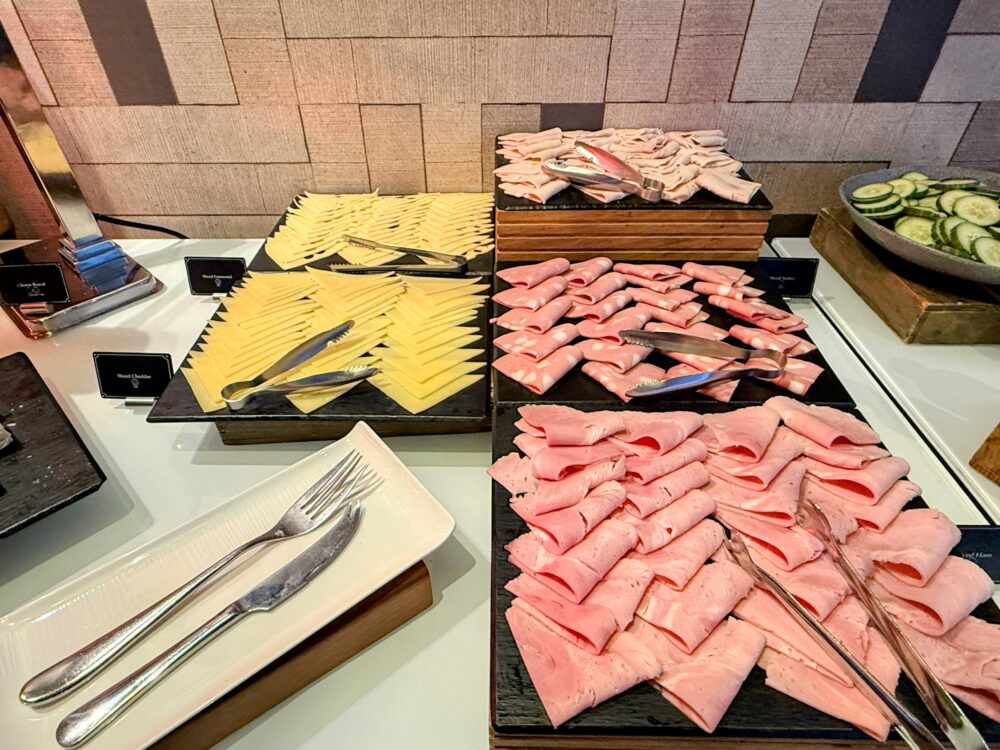 チーズ各種(エメンタルやチェダー等)と、ハムやコールドカットが綺麗に並べられたプレートコーナー