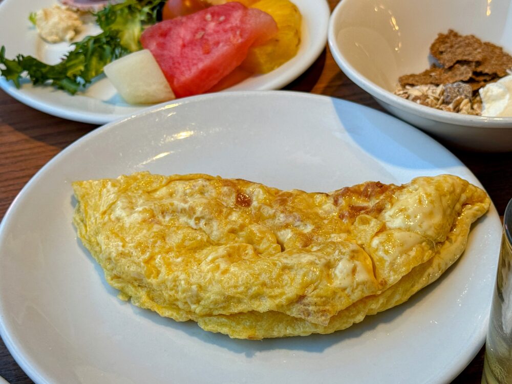 朝食ビュッフェのライブキッチン等で提供される、具だくさんのプレーンオムレツ