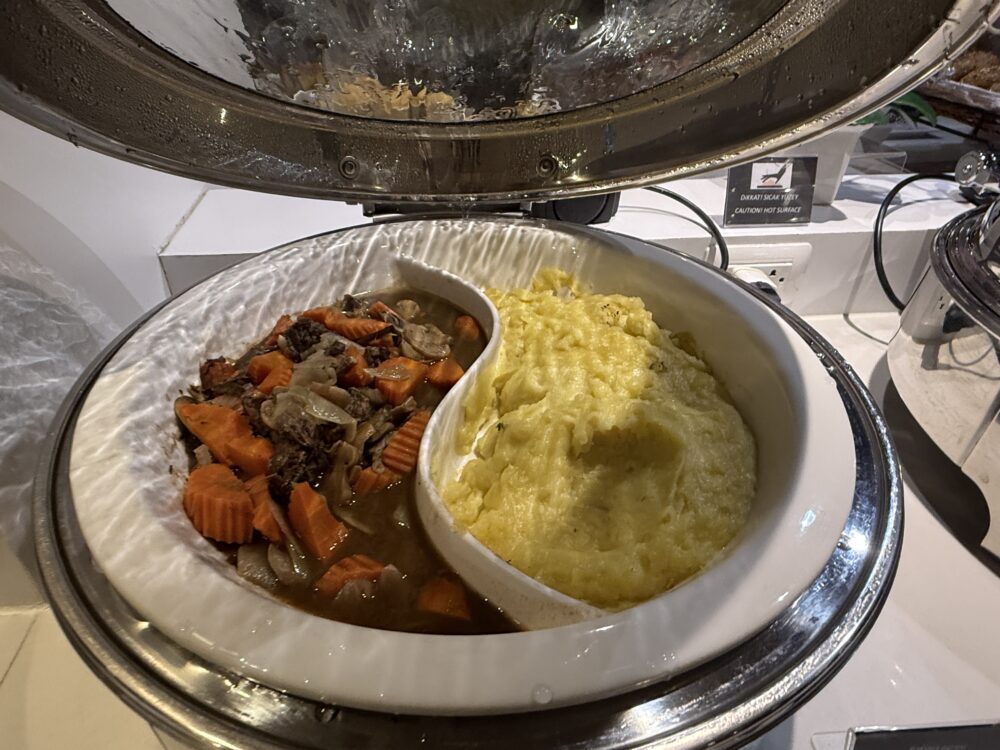 ターキッシュエアラインズ ラウンジで提供されているビーフシチュー(または煮込み料理)とマッシュポテト