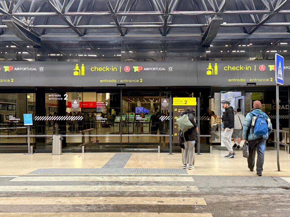 リスボン空港ターミナル1のTAPポルトガル航空チェックインカウンター入口と行き交う旅行者