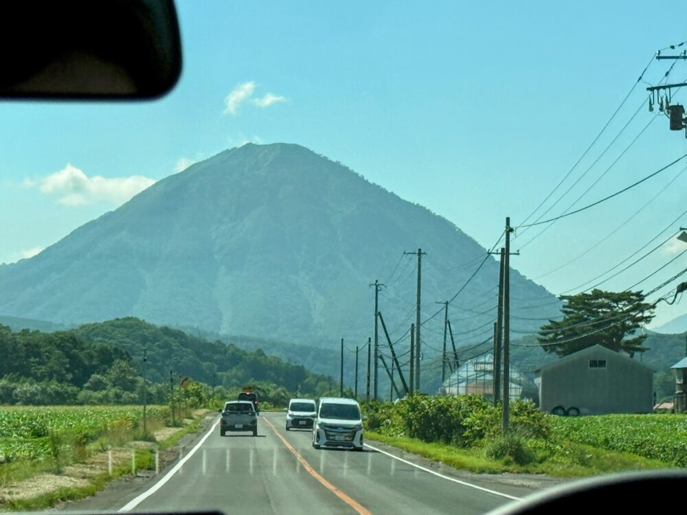 ルスツへ向かう道路の車窓から見えた円錐形の山と、走りやすい直線道路