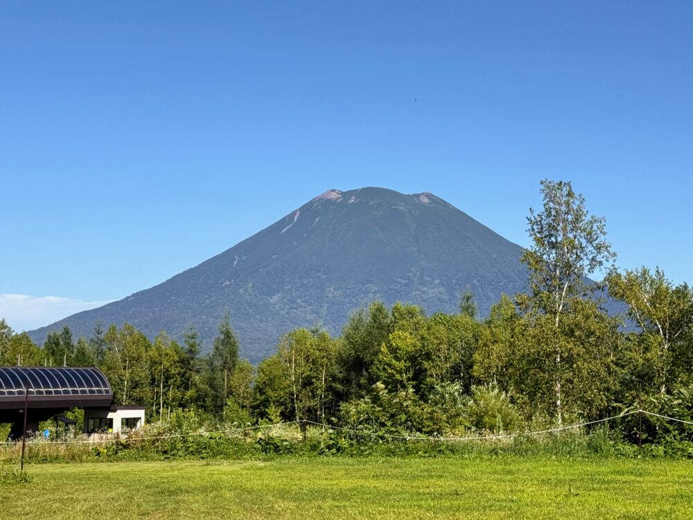 東山ニセコビレッジ・リッツ・カールトン・リザーブ周辺の美しい庭園風景。手前にはスキーのリフト乗り場があり、奥には雄大な羊蹄山がそびえ立っている。