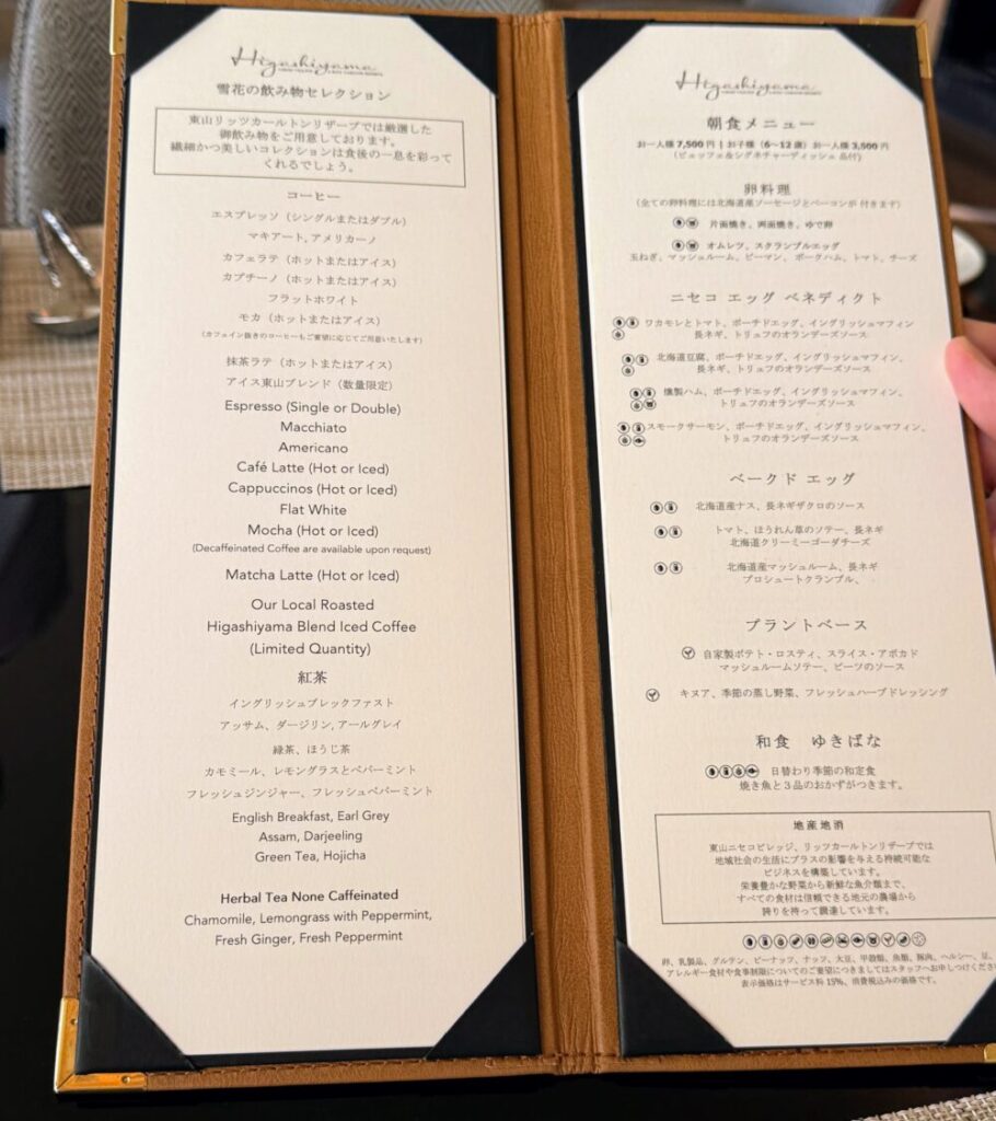 ホテルの朝食メニューとドリンクセレクションが記された革張りのメニューブックの見開き。