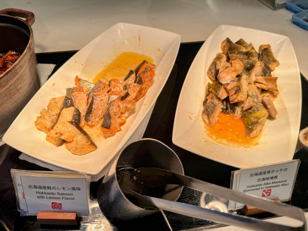 ホテルの朝食ビュッフェに並ぶ魚料理。「北海道産鮭のレモン風味」と「北海道産真ホッケの北海味噌煮」のプレート。