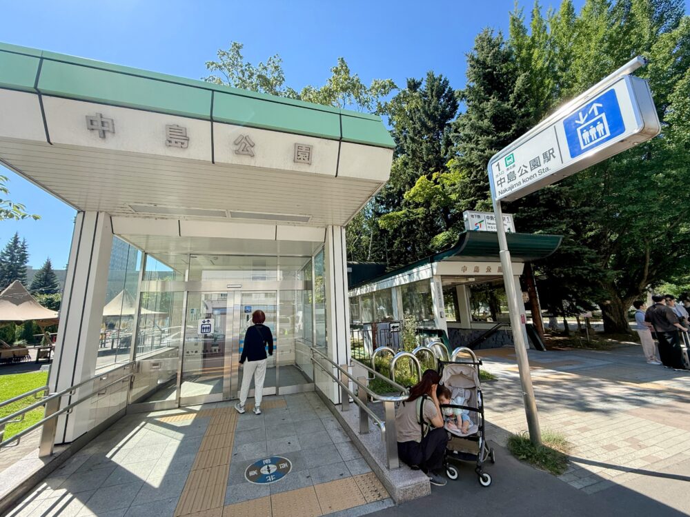 札幌市営地下鉄南北線「中島公園駅」の1番出入口付近の様子。エレベーター乗り口や周辺の木々が写っている。