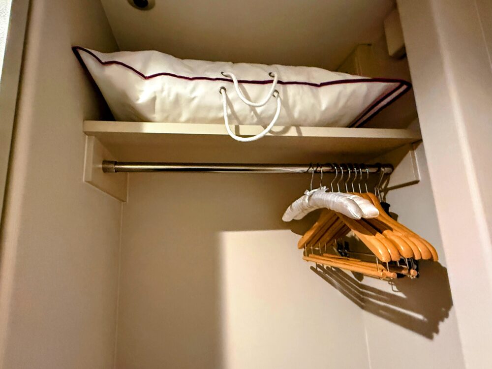 客室のクローゼット。木製ハンガーと予備の枕