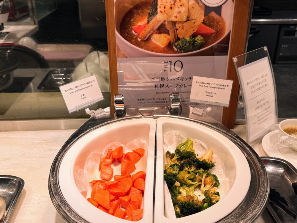 ご当地グルメキッチンの札幌スープカレー。人参とブロッコリーのトッピングを好みで足せる