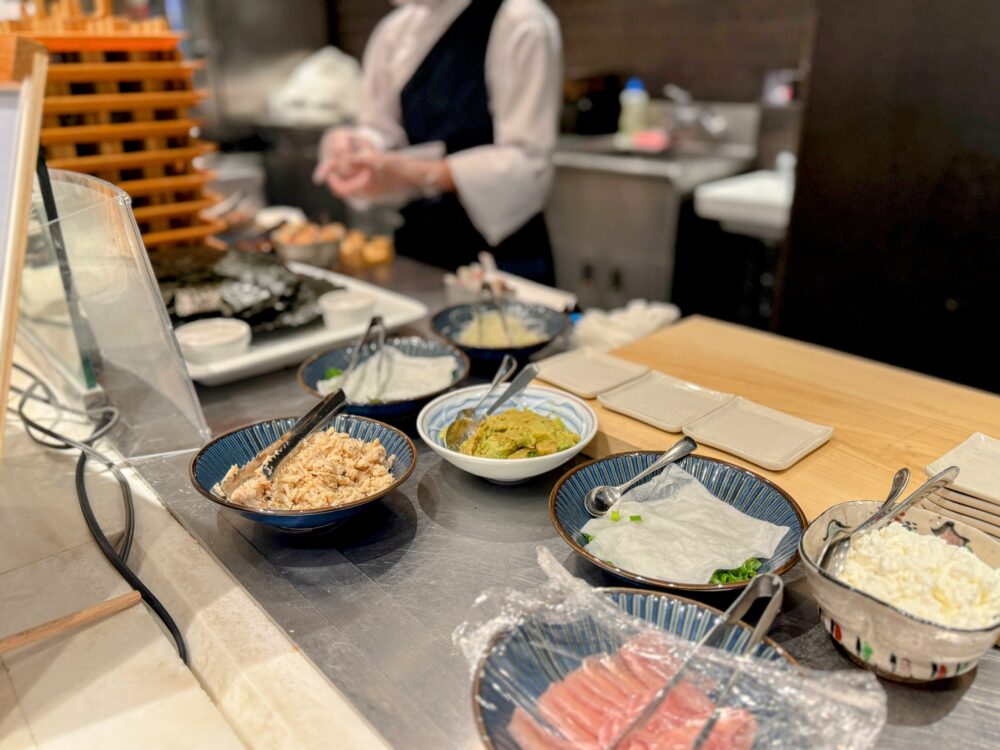 おむすびライブキッチンのカウンター全景。木製の台と具材の小鉢が並ぶ
