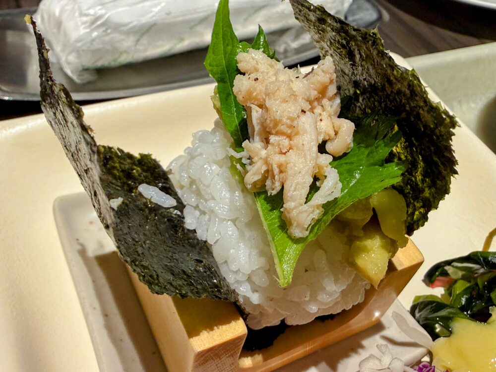 握りたての梅アボカドチキンのおむすび。大葉と蒸し鶏、アボカドがのっている