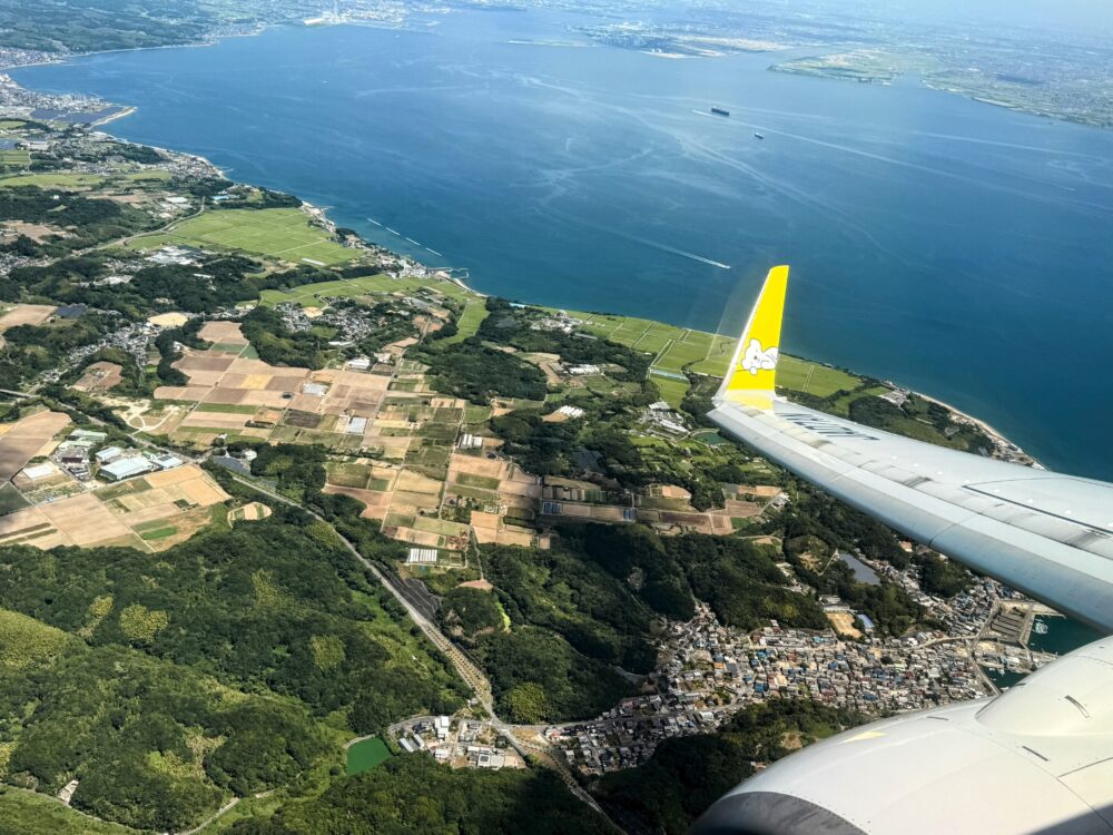 振替便となったAIR DO機の窓から見た海岸線。黄色いウィングレットが写っている