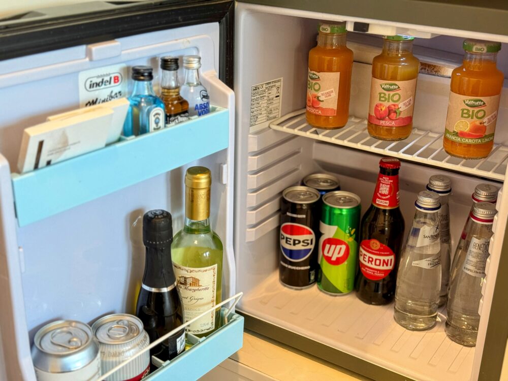 客室のミニバー（冷蔵庫）の中身。各種ソフトドリンク、ミネラルウォーター、ビール、ミニボトルのリキュール類や白ワインが綺麗に陳列されている