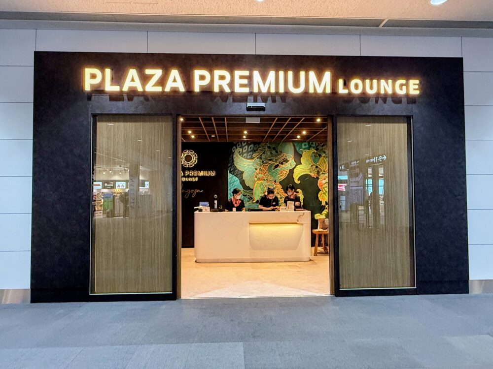 プラザ・プレミアム・ラウンジ名古屋(国内線出発)の入口。金色の「PLAZA PREMIUM LOUNGE」サインの下に受付カウンターと龍の壁画が見える。