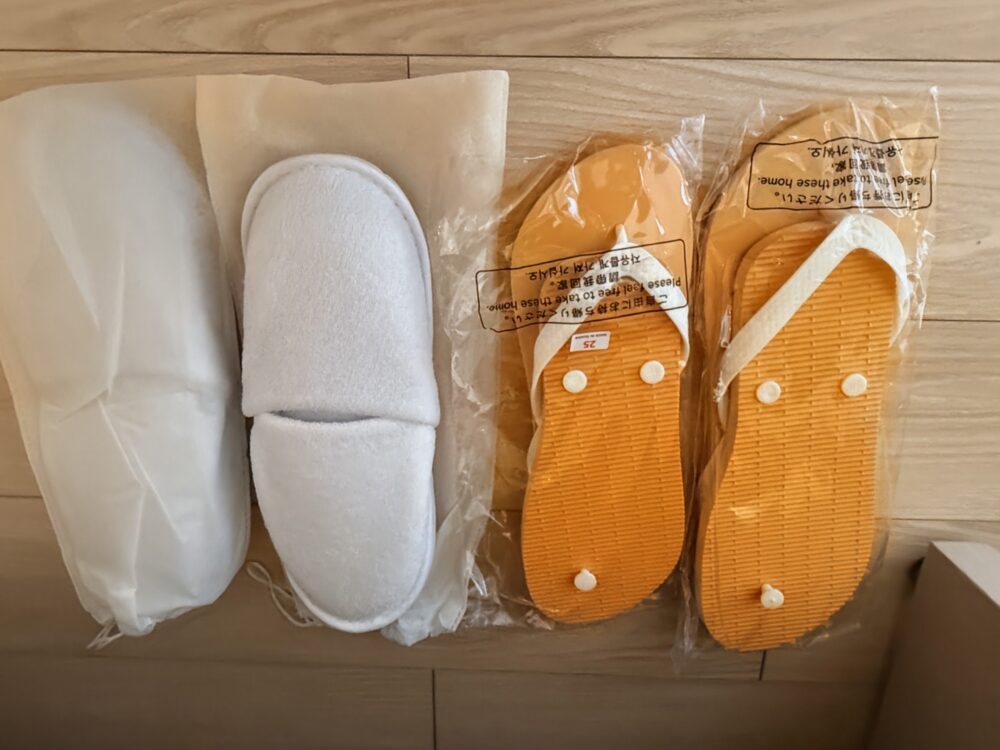 客室の室内用スリッパと、持ち帰りができるオレンジ色のビーチサンダル。