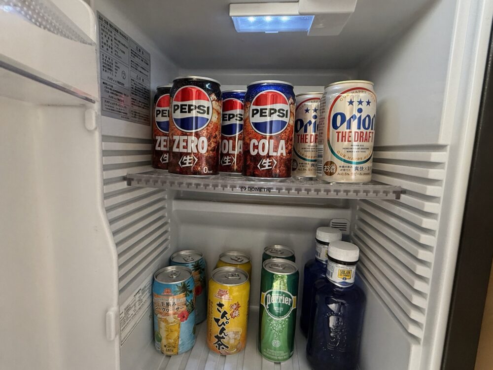 イラフSUIの客室の冷蔵庫。ペプシコーラ、ペプシゼロ、オリオンビールなどの缶飲料が並んでいる。