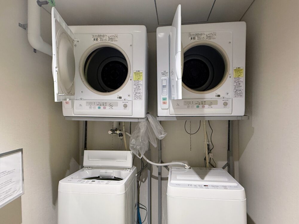 無料で使えるランドリールーム。洗濯機2台の上に乾燥機2台が設置されている。