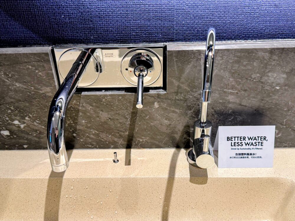 部屋の浄水器の蛇口と「BETTER WATER, LESS WASTE」のカード
