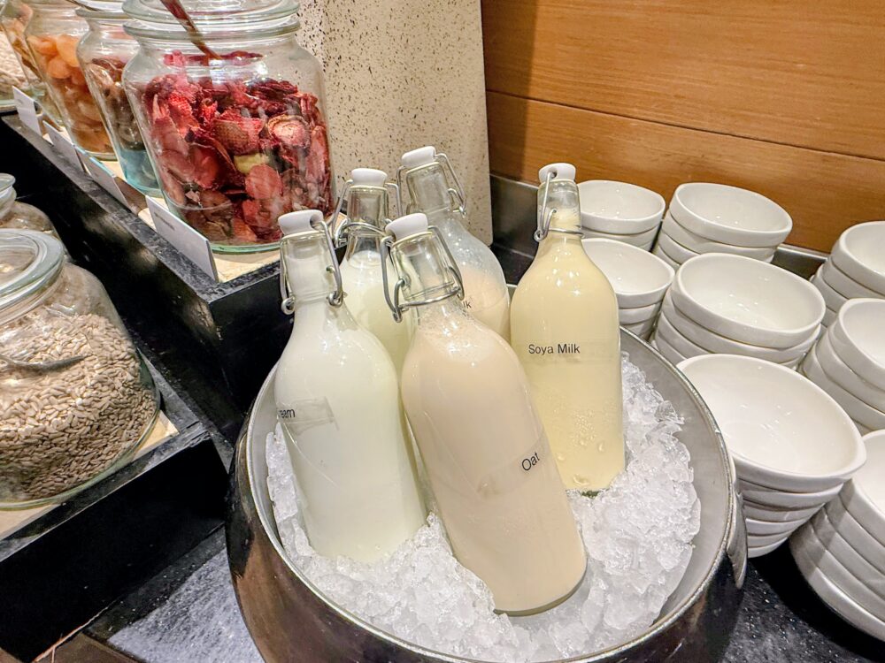 朝食ビュッフェの氷で冷やした瓶入りのオーツミルクと豆乳