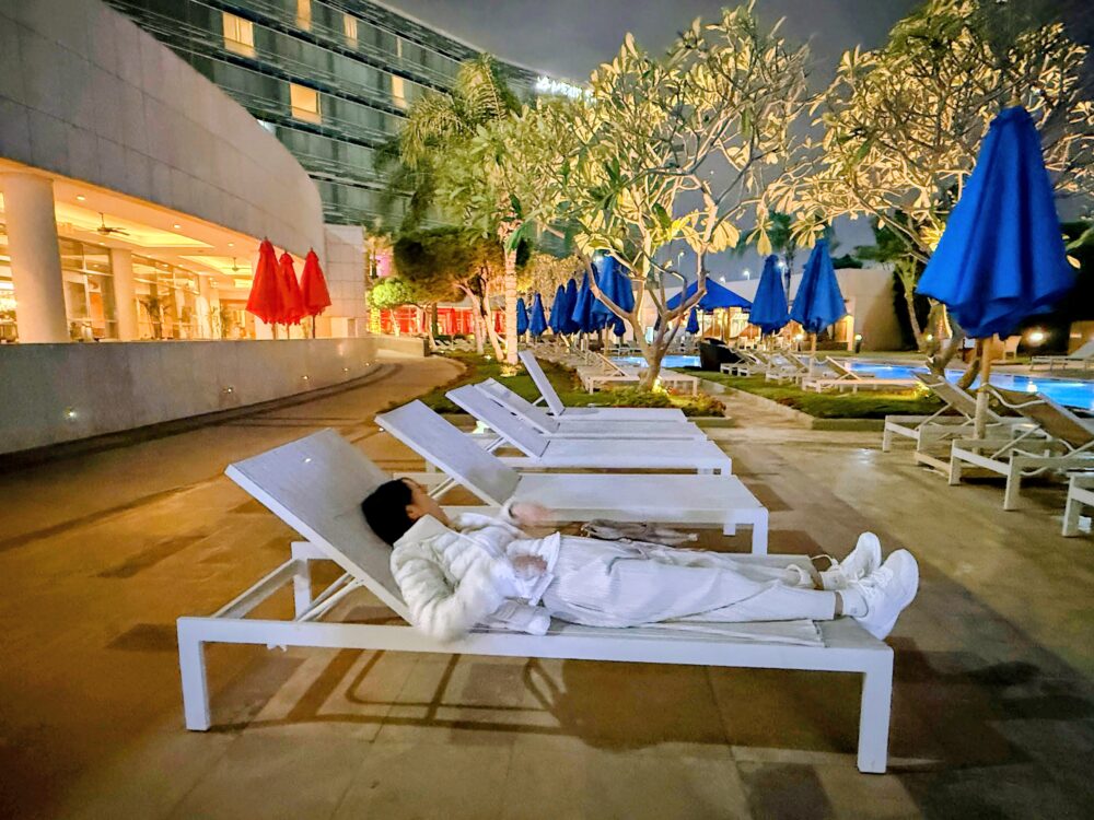 夜のプールサイドに並ぶデッキチェア