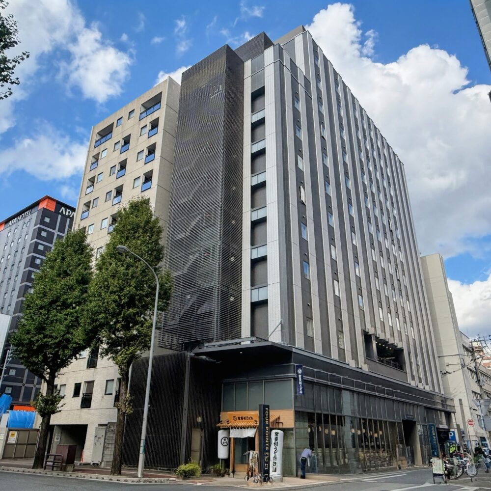 フォーポイント・フレックス・バイ・シェラトン福岡博多の外観（青空と建物全体）