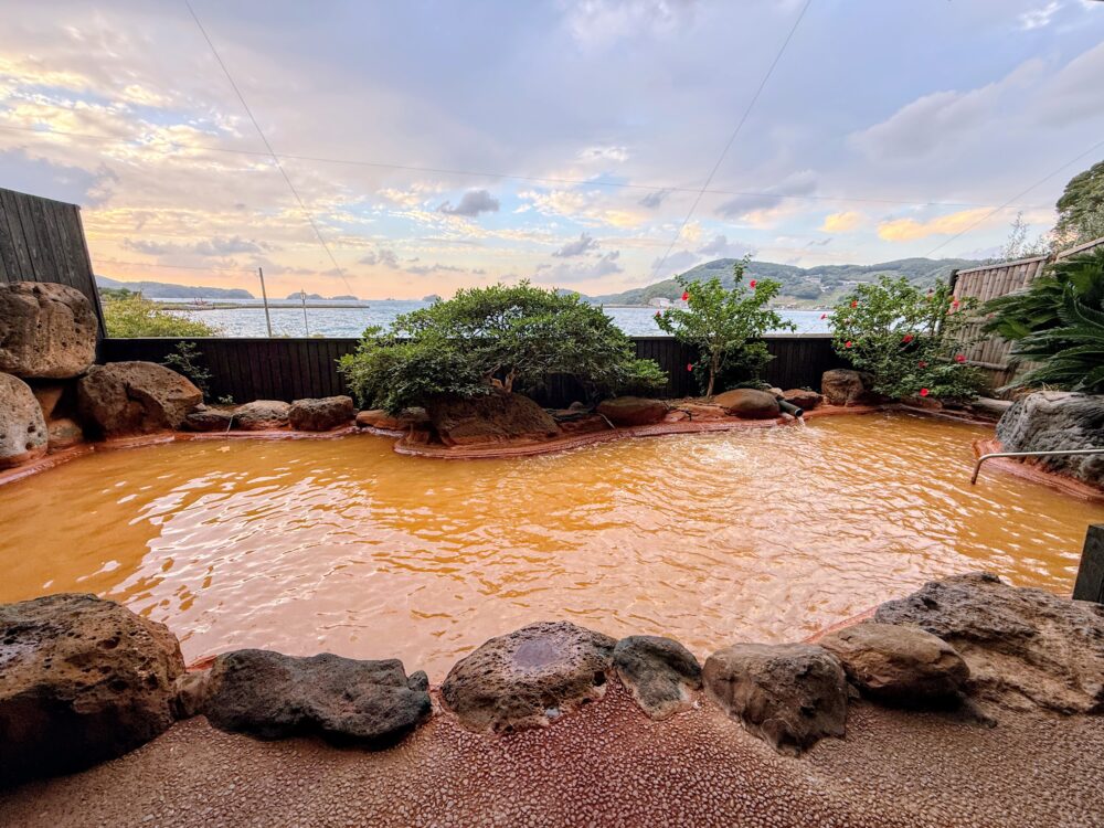 女性大浴場の茶色い源泉の露天風呂と夕方の海